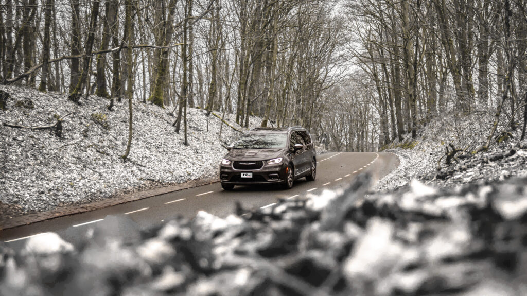 Auto van kienlease in de wintersportverhuur rijdend door sneeuwig gebied